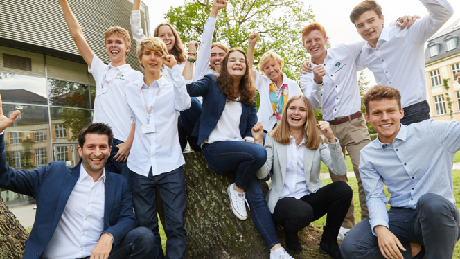 ©YES!-Young Economic Solution Eine Gruppe Schüler:innen und ein Lehrer jubeln.