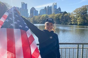 Die ehemalige Stipendiatin Anna Börner mit einer US-Flagge vor der Skyline Atlantas