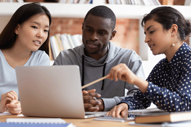 Wissenschaftler:innen sitzen an einem Laptop und besprechen sich.