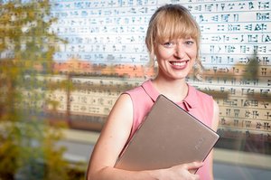 Die ehemalige Add-on Fellow Prof. Dr. Janina Steinert, TU München, steht mit einem Laptop vor einer gläsernen Wand.