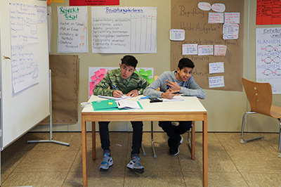 Zwei Jungs sitzen an einem Tisch im Klassenzimmer und lernen
